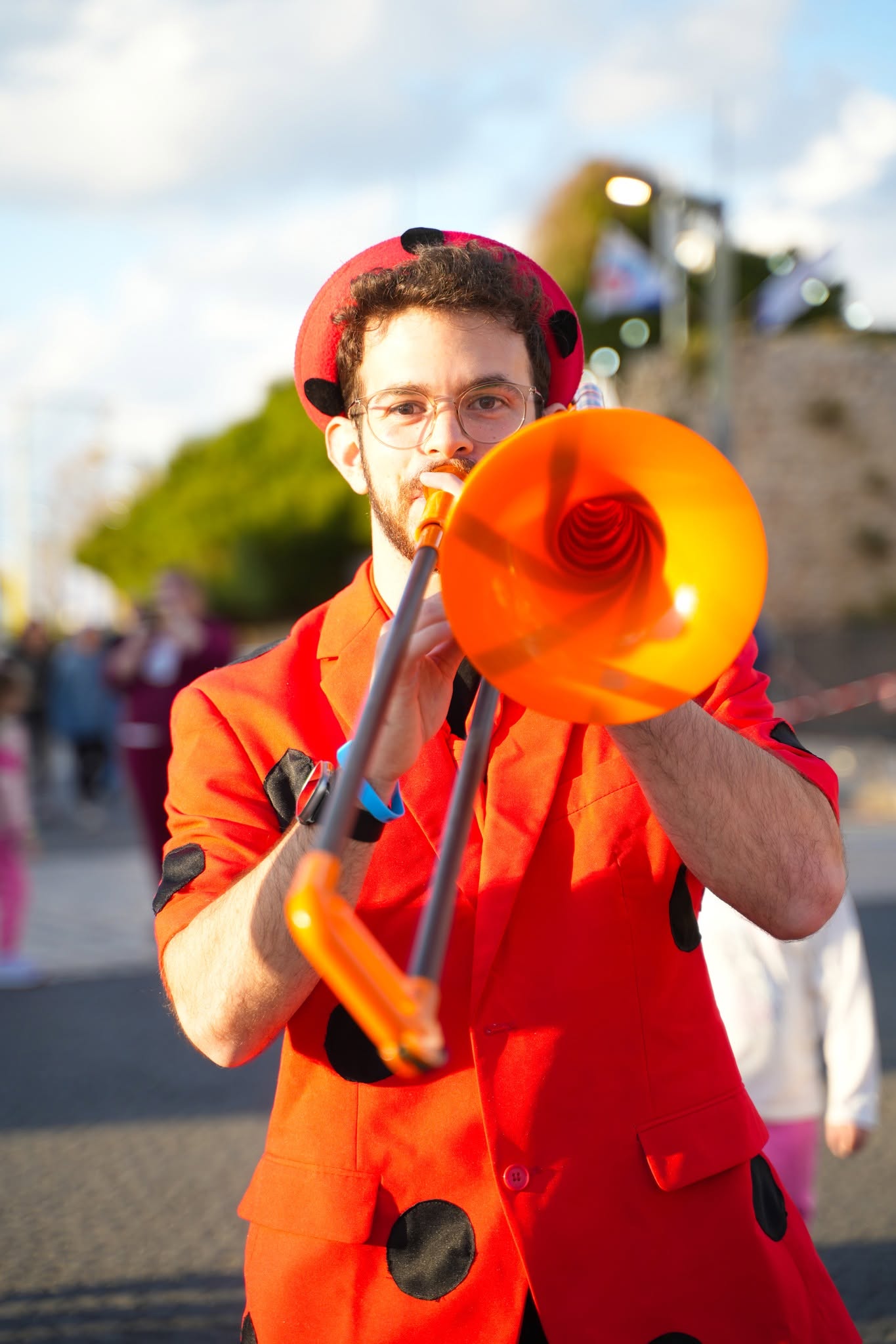 אמן רחוב מנגן בחצוצרה כתומה.