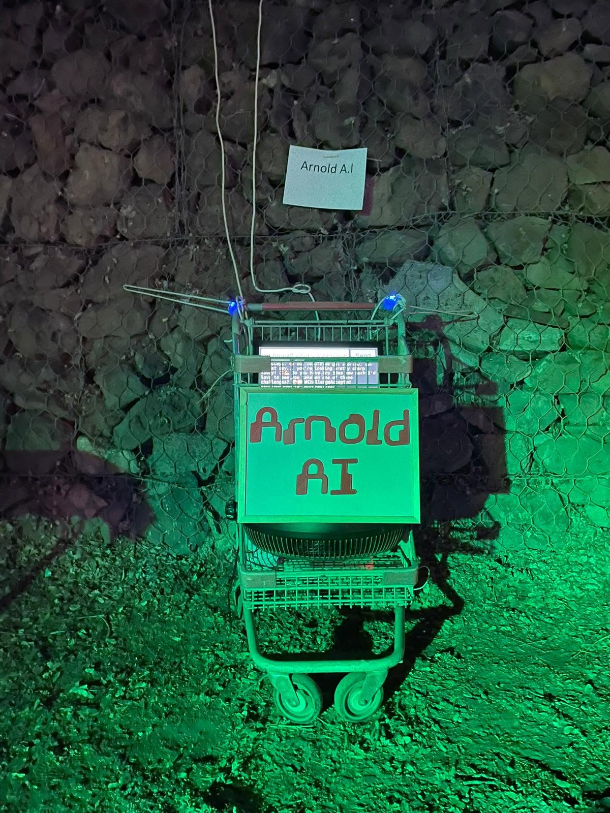 שלט Arnold AI תלוי על מתקן מואר בירוק.