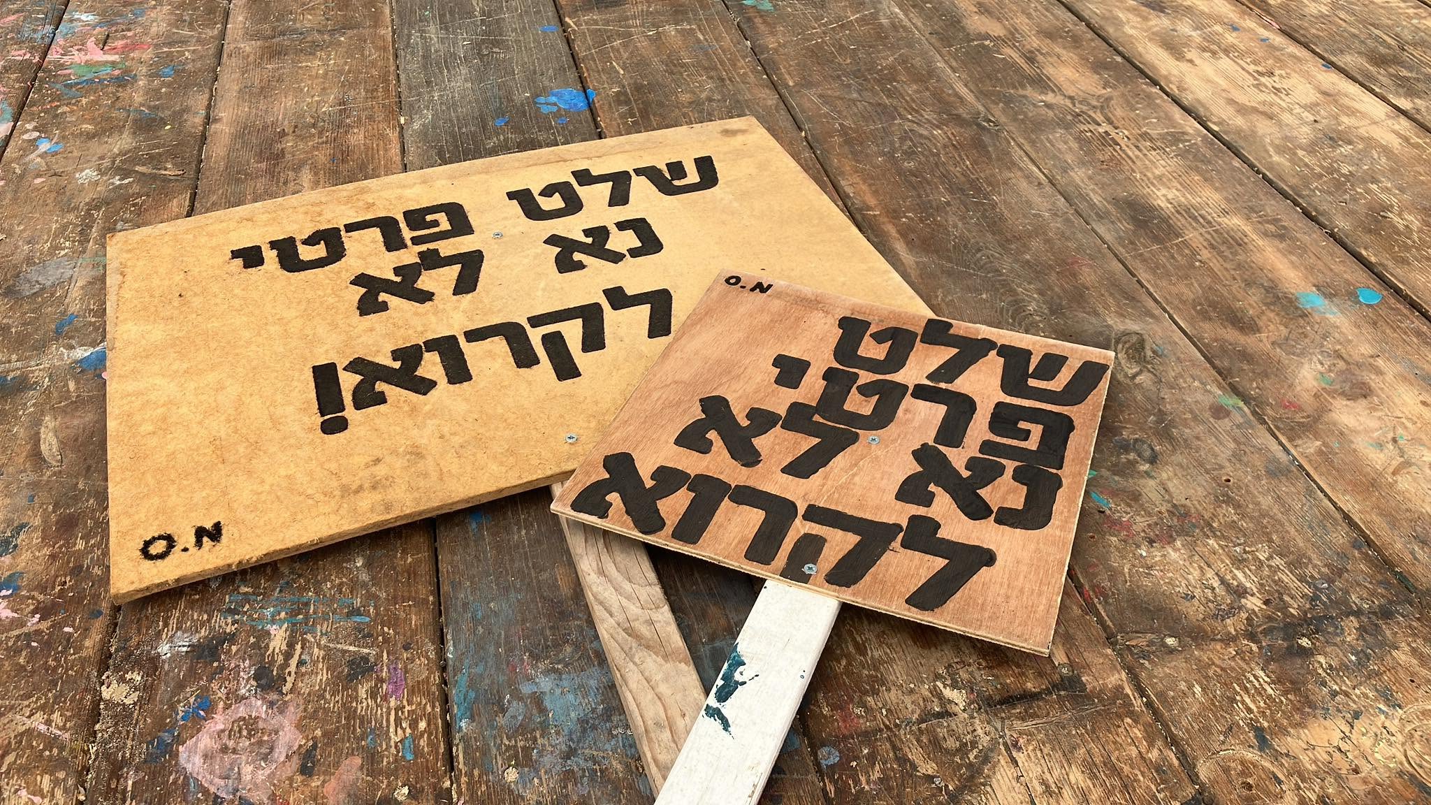 שלטי עץ כתובים ביד מונחים על שולחן.