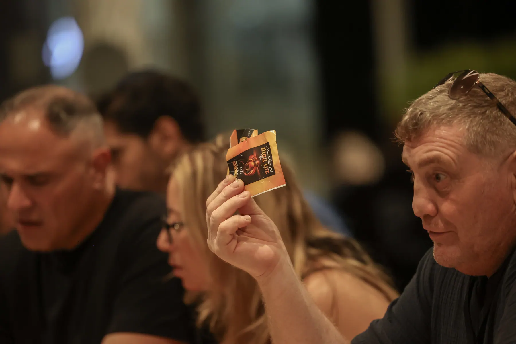 מבקר מחזיק כרטיס ליד פניו במהלך טעימה.